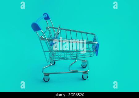 supermarket trolley on blue background Stock Photo