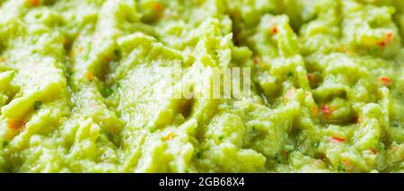 Guacamole close-up. Avocado guacamole sauce with fresh ingredients. Food background of guacamole sauce Stock Photo