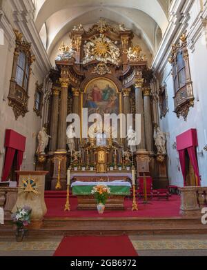 VIENNA, AUSTIRA - JUNI 17, 2021: The  prebytery and main altar of baroque church  Alserkirche with the Holy Trinity painting Stock Photo