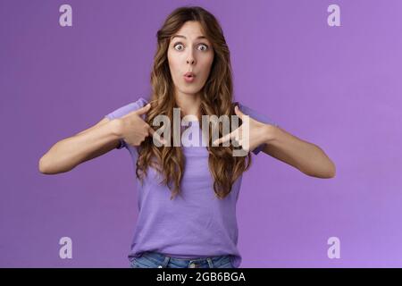 You mean me. Surprised cheerful silly caucasian female student pointing herself impressed astonished choice was picked chosen folding lips excitement Stock Photo