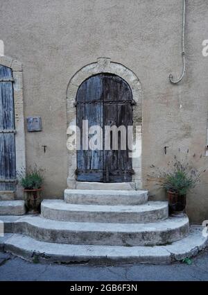 Old wooden door in the old town, lavender pots, Lourmarin, Provence, France Stock Photo