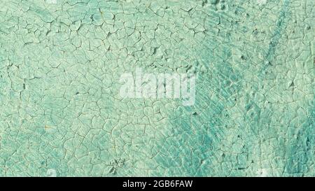 Cracked turquoise paint texture. Old crackled teal turquoise painted wood surface. Green turquoise painted cracked wall texture Stock Photo