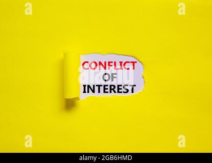 Conflict of interest symbol. Words 'Conflict of interest' appearing behind torn yellow paper. Beautiful yellow background. Business, conflict of inter Stock Photo