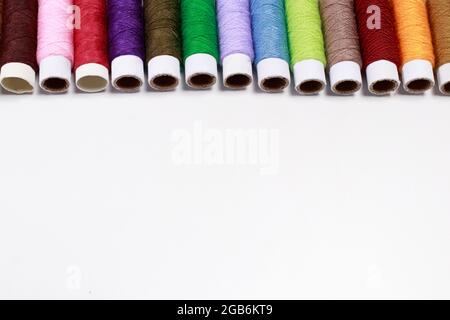 Set of multi-colored skeins of thread on a white background with place for text. Sewing or tailor shop, for advertising. Stock Photo