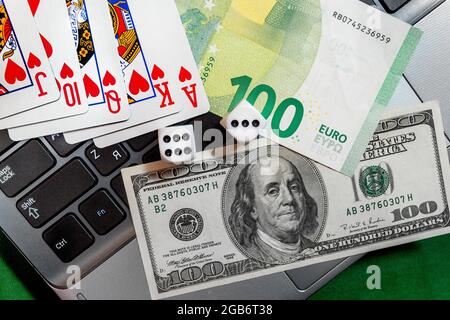 Dice, playing cards, dollars on a computer background Stock Photo