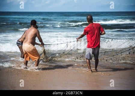 A fisherman pulling a rope line from his net, wood catch device on the ...