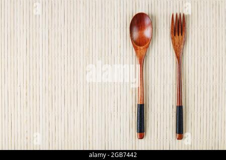 Wooden spoon, fork on a bamboo backing. Asian food handicraft concept. View from above Stock Photo