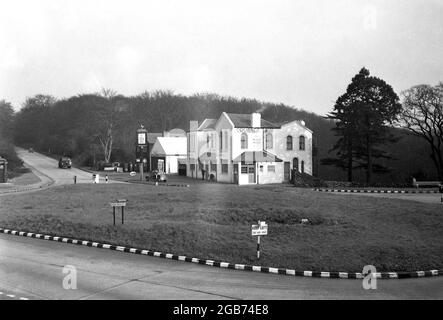 1954, historical view from this era of The Robin Hood Inn on Epping New Rd at Loughton, Essex, England, UK. Built around 1865 and situated on the edge of Epping Forest, at this time in the 1950s, there was a small garage with petrol pumps, beside the pub. The roundabout seen here was constructed in the 1920s, as the road beside the pub had become well-known as a blackspot for road accidents, so much so, that a policeman was often seen standing in the road. Stock Photo