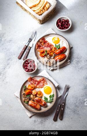English breakfast with fried eggs, bacon, sausages, beans, toasts on white background Stock Photo