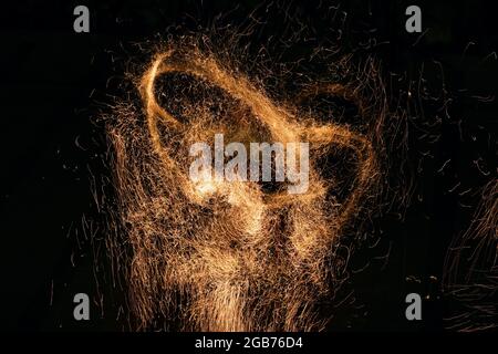 Burning red hot sparks. Beautiful abstract background on the theme of fire, light and life. Fiery orange glowing flying particles on black background Stock Photo