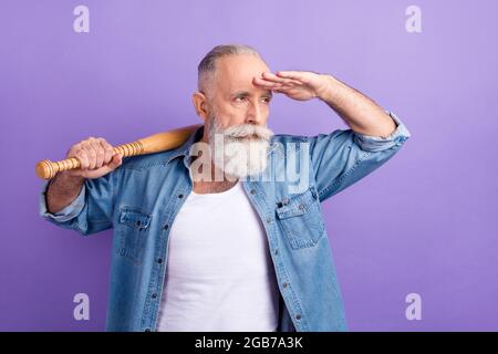 Photo of strong serious mature man dressed denim holding bit arm forehead looking far away delivery isolated purple color background Stock Photo