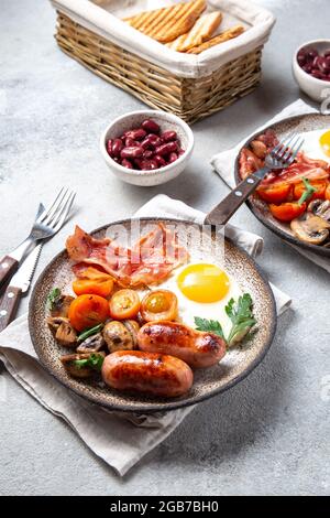 English breakfast with fried eggs, bacon, sausages, beans, toasts on white background Stock Photo