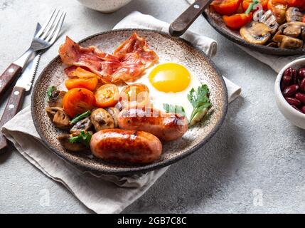 English breakfast with fried eggs, bacon, sausages, beans, toasts on white background Stock Photo