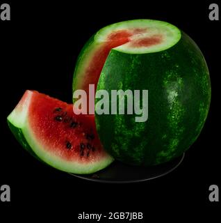 Watermelon with cut discount on black plate on black background isolated Stock Photo