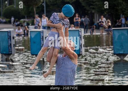 Moscow, Russia. 2nd of August, 2021 Grandfather and grandson bathe in the fountain of the Gorky Central Park on the Day of the Airborne Troops on a hot summer day in Moscow, Russia Stock Photo