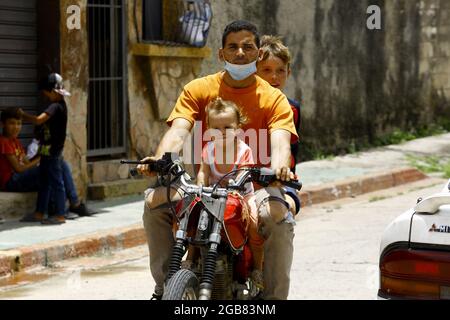 Valencia, Carabobo, Venezuela. 31st July, 2021. July 31, 2021. A man rides with his children on a motorcycle in the city of Valencia, Carabobo state. Photo: Juan Carlos Hernandez (Credit Image: © Juan Carlos Hernandez/ZUMA Press Wire) Stock Photo