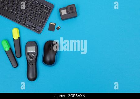 Top View of Photographer's, Videographer's or Video Blogger's Workplace. Digital Gadgets Lying on Blue Table - Flat Lay Stock Photo