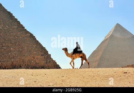 Mounted (Camelus dromedarius) tourist police on camel, in the background Pyramids of Giza, Cairo, Egypt Stock Photo
