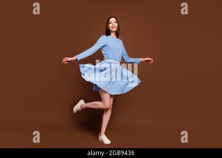 Full size photo of lovely millennial brunette lady dance wear blue dress isolated on brown color background Stock Photo