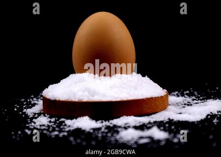 An egg above the salt or salty egg in black background in HD size Stock Photo