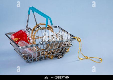 Mini shopping cart filled with jewellery. Stock Photo
