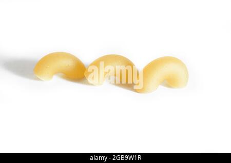 Three macaroni horns isolated on a white background. Macro.  Stock Photo