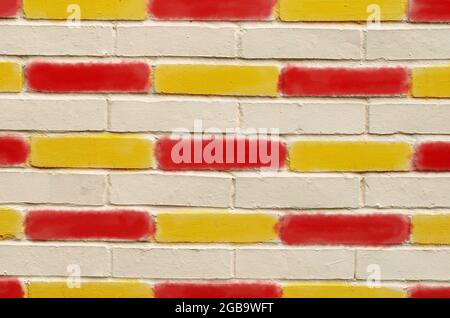 Brick wall, with red and yellow painted bricks Stock Photo