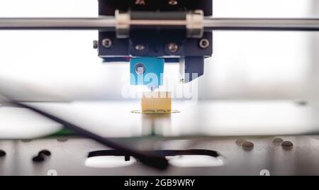 3D printer developing plastic yellow product. Closeup view of printing process Stock Photo