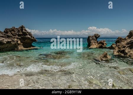 Turquoise emerald water of the Mediterranean Sea.Amazing view of calm seaside,rocky seashore,mountains in background.Holiday travel scenery copy space Stock Photo