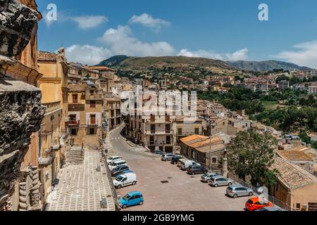 Caccamo, Sicily, Italy. View of popular hilltop medieval town and Piazza Duomo with cars.Medieval town with famous impressive Norman castle. Stock Photo