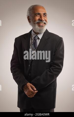 A HAPPY OLD MAN WEARING FORMALS LOOKING ABOVE AND SMILING Stock Photo