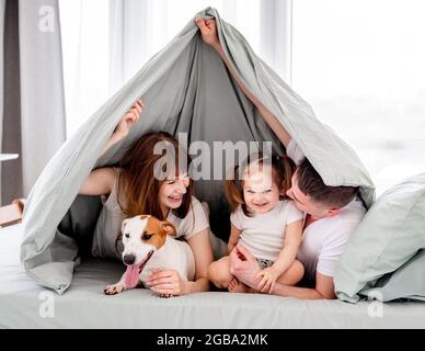 Family under the blanket in the bed Stock Photo