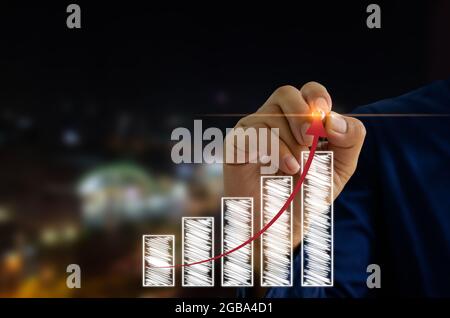 Businessman hand and pen touching virtual screen graph and arrow. Business concept  investment and growth. Stock Photo