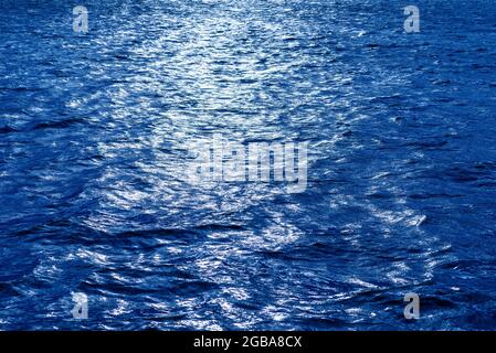 Water Waves Background. Blue Tones Water Surface. Blue sunny sea water surface.Toned. Stock Photo