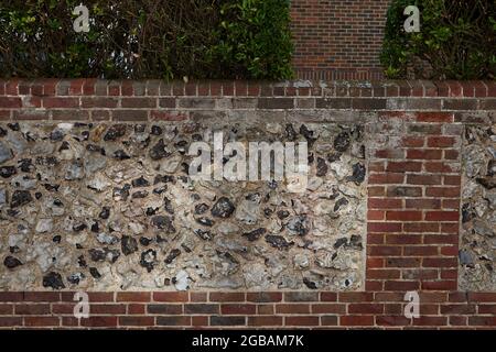 Flint wall with bricks. Stock Photo