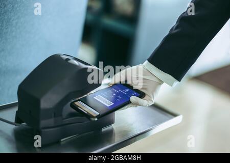 Passenger scanning her boarding pass as a machine issuing sign on code ...
