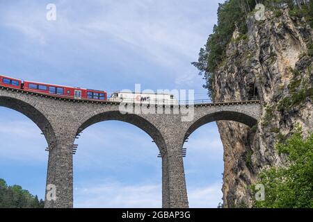 Filisur, Switzerland - June 17, 2021: A train is crossing a famous Landwasser viaduct nearby Filisur town in the swiss alps Stock Photo