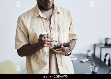 Young businessman standing at office and using digital tablet for his online work Stock Photo