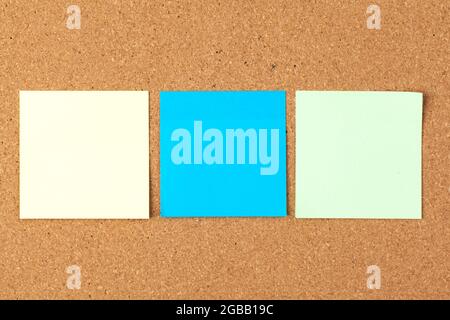 Cork board with several colorful blank notes with pins Stock Photo