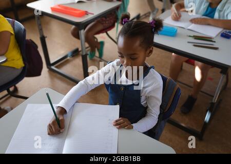 African american girl studying while sitting on her desk in the class at school Stock Photo