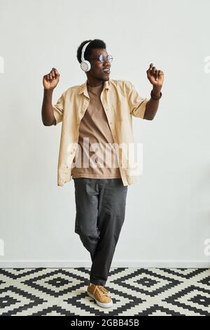 African young dancer in wireless headphones listening to music and performing dance exercises Stock Photo