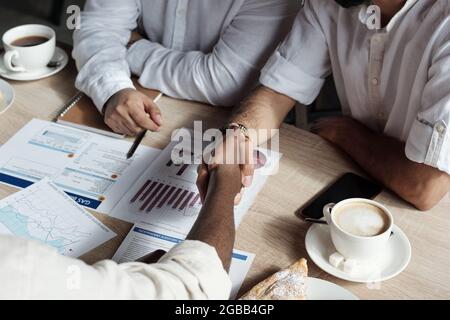 Two Arabic businessmen shaking hands over table while making agreement Stock Photo