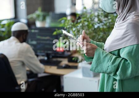 Hands of Muslim businesswoman using digital tablet in working environment Stock Photo