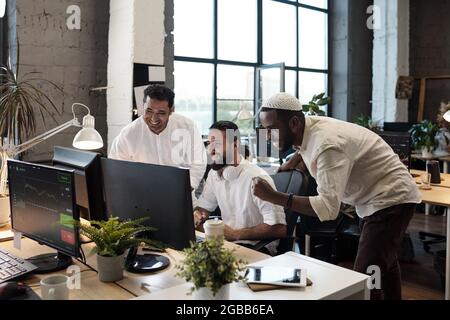 Young successful businessmen looking at computer screen with smiles Stock Photo