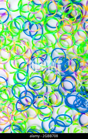 Colorful rubber bands on green background Stock Photo by