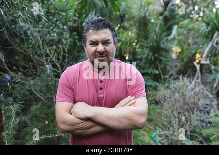 Portrait of caucasian male gardener with crossed hands looking at camera at garden centre Stock Photo