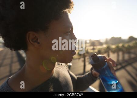 Fit african american man exercising in city resting and drinking water Stock Photo
