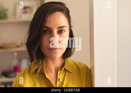 Portrait of caucasian woman wearing yellow shirt and looking at camera Stock Photo