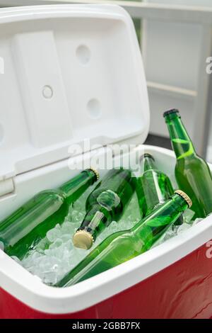 Several green bottles of fresh cold beer in box with ice cubes Stock Photo