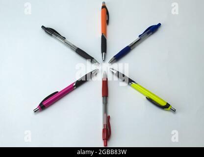 foreground of color pens lined up in a star shape on a white background Stock Photo